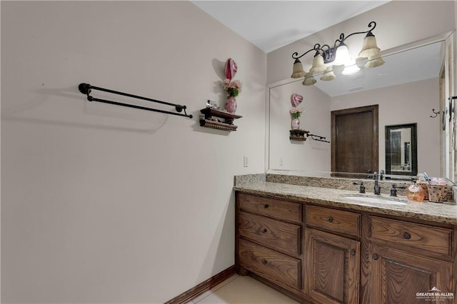 bathroom with vanity, tile patterned floors, and baseboards