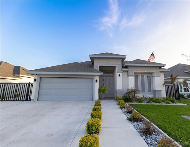 prairie-style house featuring a garage, driveway, fence, a front yard, and stucco siding