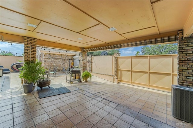view of patio featuring central AC and a fire pit