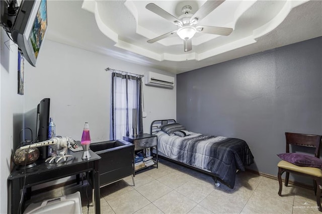 bedroom with a tray ceiling, ceiling fan, a wall unit AC, and light tile patterned flooring