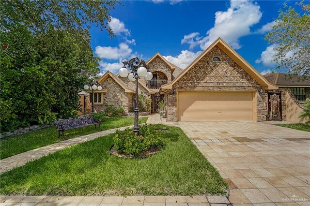 228 Oak Ridge Dr, Rio Grande City, TX 78582 - view of front facade featuring an attached garage, decorative driveway, a front yard, brick siding, and stone siding