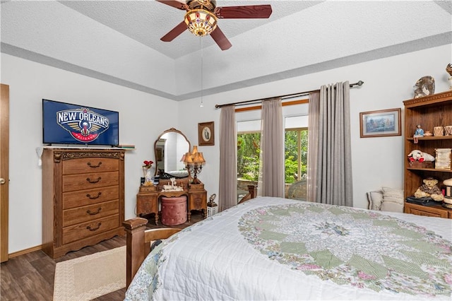 bedroom featuring access to exterior, ceiling fan, dark hardwood / wood-style flooring, and a textured ceiling