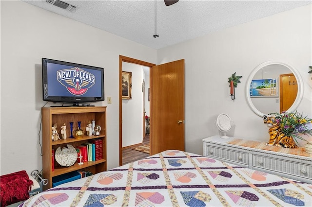 bedroom featuring wood-type flooring, a textured ceiling, and ceiling fan