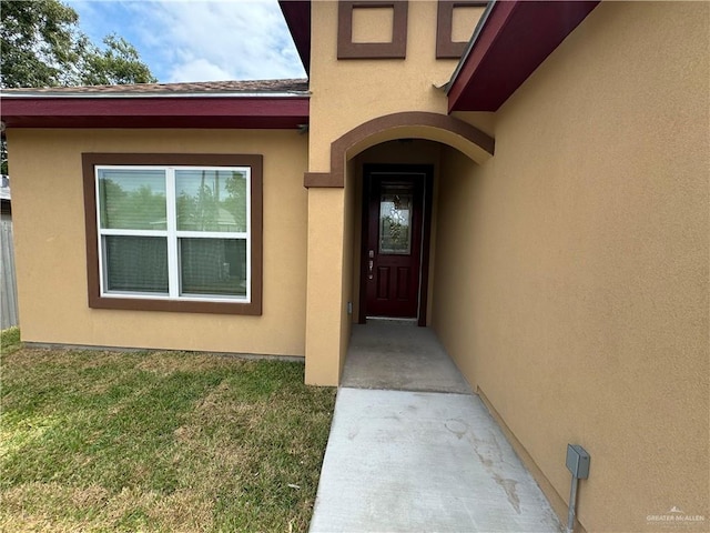 view of exterior entry with a lawn