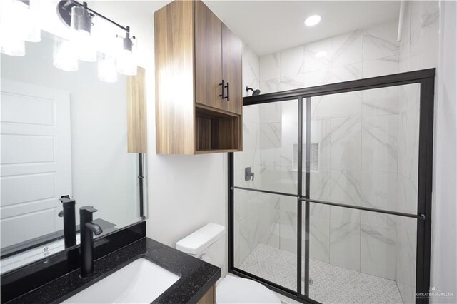 bathroom with toilet, a stall shower, recessed lighting, and vanity