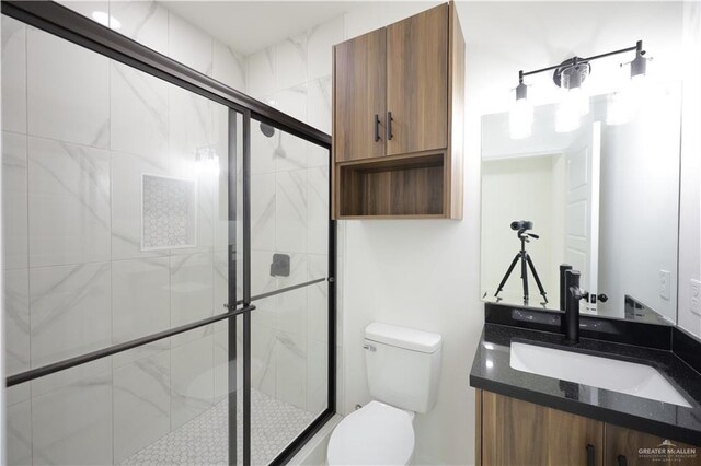 full bathroom with toilet, a stall shower, and vanity