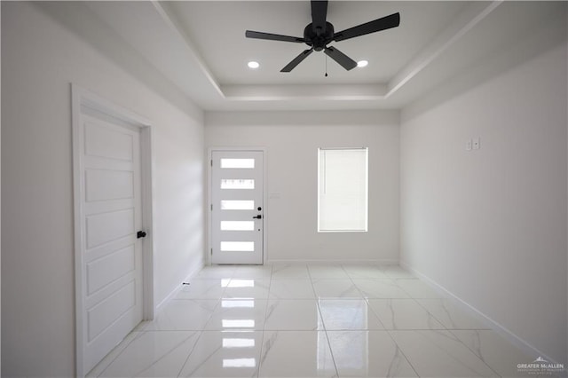 entryway featuring a tray ceiling, recessed lighting, a ceiling fan, and baseboards