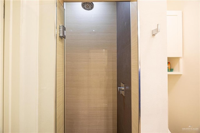 interior details featuring tiled shower