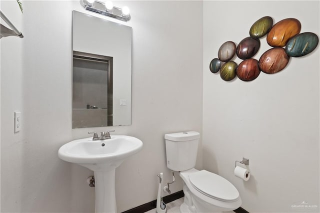bathroom featuring baseboards and toilet
