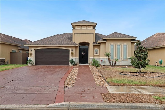 view of front of home with a garage, driveway, stucco siding, and roof with shingles