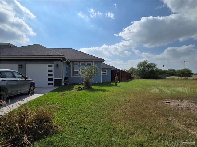 view of side of home featuring a yard and a garage