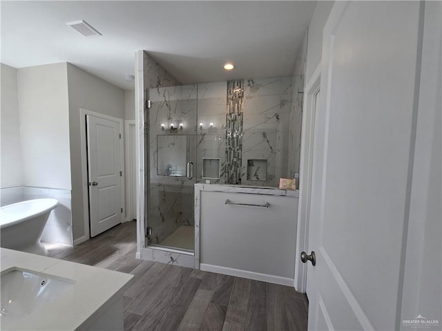 bathroom featuring vanity, wood-type flooring, and independent shower and bath