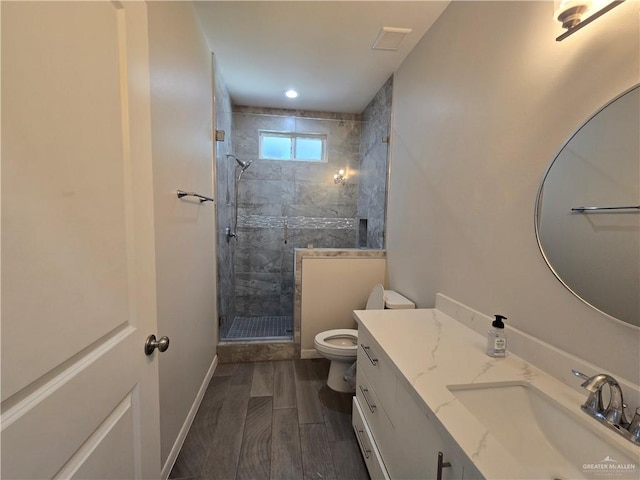 bathroom featuring wood-type flooring, vanity, toilet, and an enclosed shower