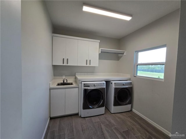 laundry area featuring washer and clothes dryer, dark hardwood / wood-style flooring, cabinets, and sink