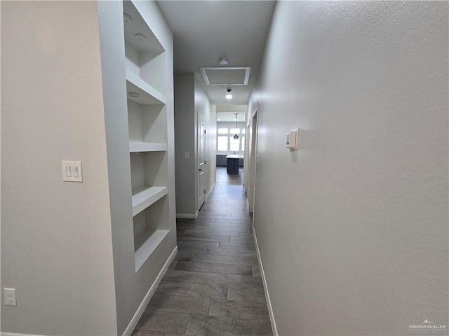 corridor with dark hardwood / wood-style flooring and built in features