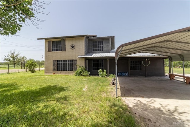 back of property with a yard and a carport