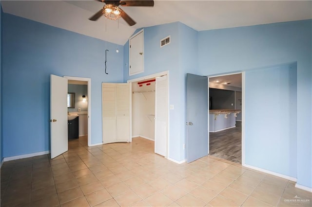 unfurnished bedroom featuring connected bathroom, ceiling fan, high vaulted ceiling, light hardwood / wood-style floors, and a closet