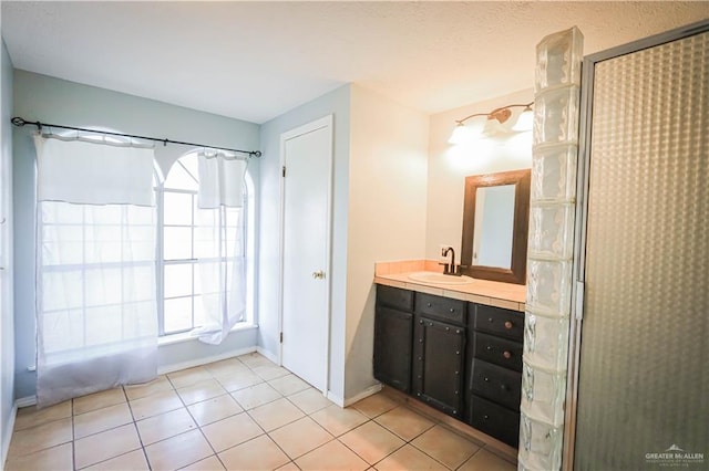 bathroom featuring tile patterned flooring, vanity, and walk in shower