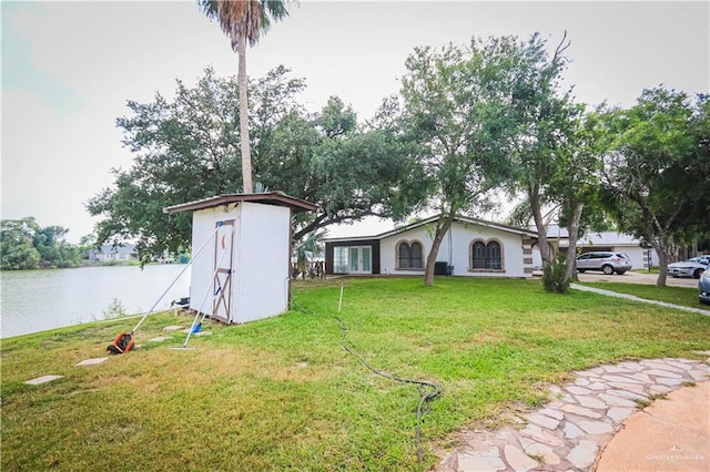 view of yard with a water view and a storage unit