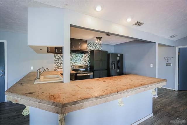 kitchen with kitchen peninsula, electric range, black fridge, and sink