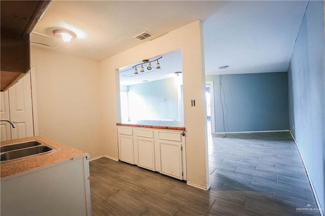 kitchen featuring dark hardwood / wood-style flooring, white cabinetry, and sink