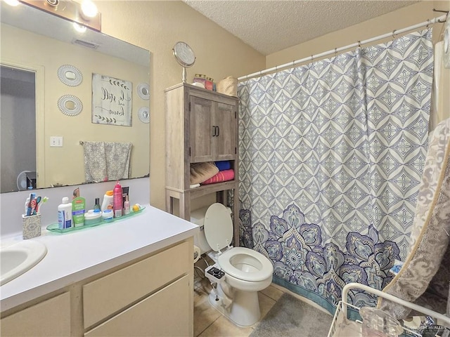 bathroom featuring tile patterned flooring, vanity, a textured ceiling, and toilet