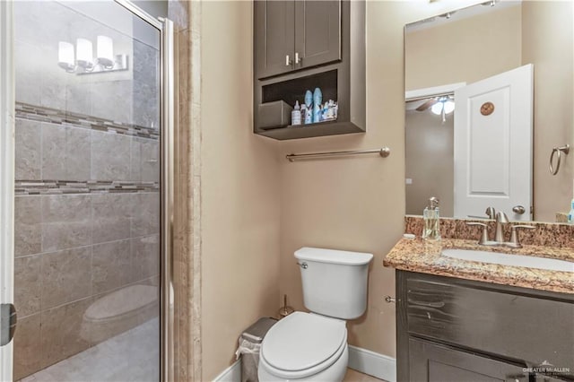 bathroom featuring walk in shower, ceiling fan, vanity, and toilet