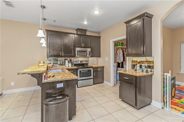 kitchen with decorative light fixtures, sink, dark brown cabinets, and stainless steel appliances