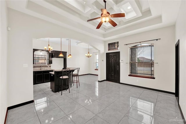 foyer with coffered ceiling, sink, a healthy amount of sunlight, and a high ceiling