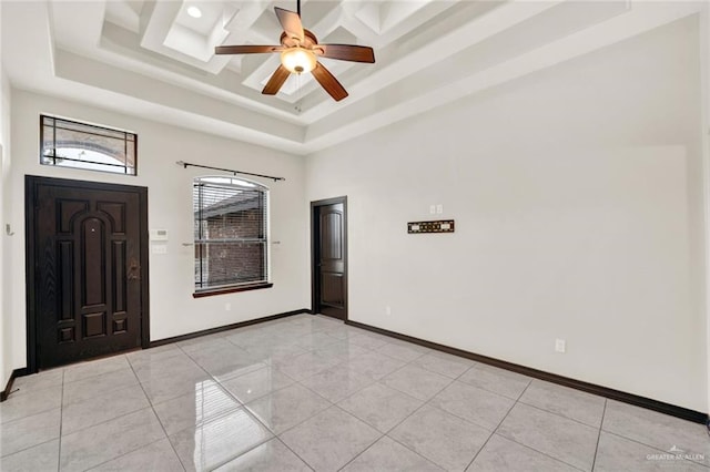 entryway featuring ceiling fan, a tray ceiling, a high ceiling, and light tile patterned floors