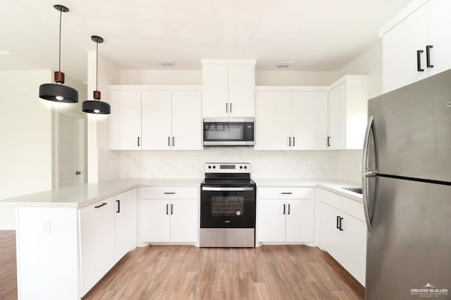 kitchen with white cabinetry, light hardwood / wood-style flooring, kitchen peninsula, decorative light fixtures, and appliances with stainless steel finishes