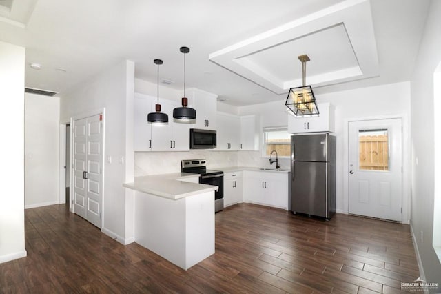 kitchen with dark hardwood / wood-style flooring, stainless steel appliances, sink, pendant lighting, and white cabinets