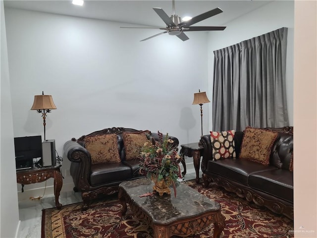 living room with ceiling fan and baseboards