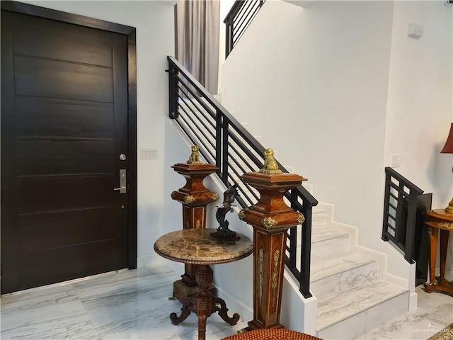 entryway featuring marble finish floor and stairway