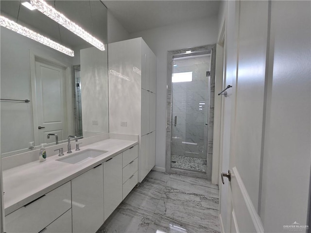full bath with vanity, marble finish floor, and a stall shower