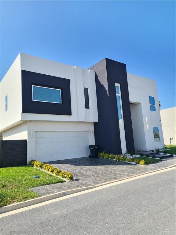 modern home with a garage, stucco siding, and driveway