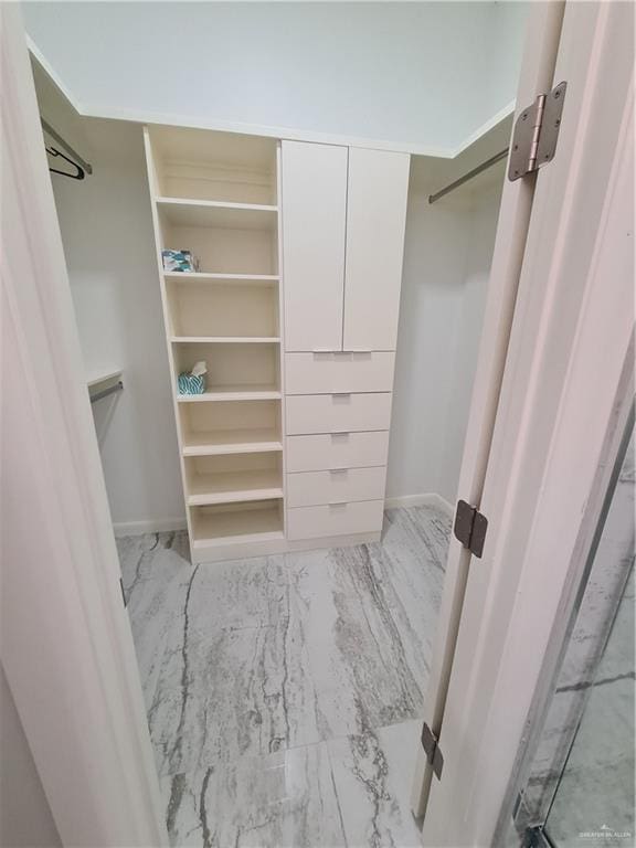 walk in closet with marble finish floor