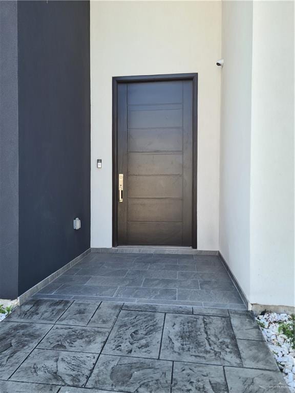 view of exterior entry featuring stucco siding