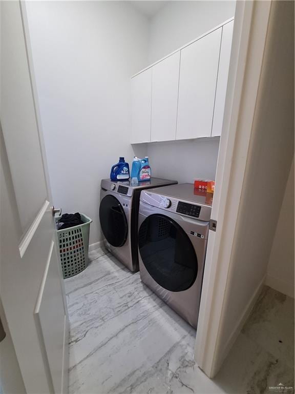 laundry area with separate washer and dryer, marble finish floor, cabinet space, and baseboards