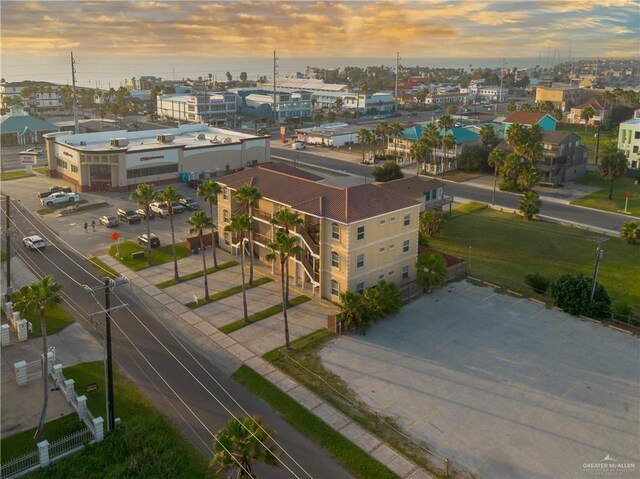 aerial view at dusk featuring a water view