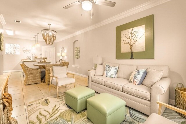 tiled living room featuring ceiling fan with notable chandelier and ornamental molding