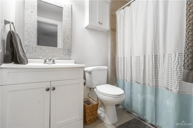 bathroom with tile patterned flooring, vanity, toilet, and walk in shower