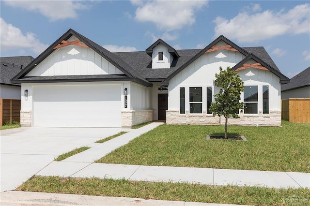 1027 Broken Arrow Dr, Alamo, TX 78516 - view of front facade with stone siding, an attached garage, driveway, roof with shingles, and board and batten siding