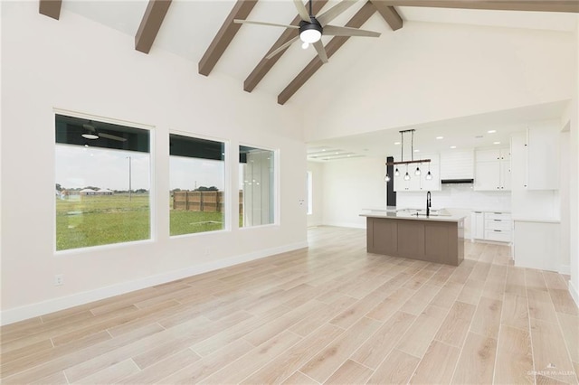 1027 Broken Arrow Dr, Alamo, TX 78516 - unfurnished living room with a ceiling fan, beam ceiling, light wood finished floors, high vaulted ceiling, and a sink