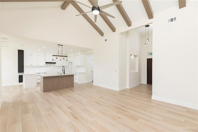 1027 Broken Arrow Dr, Alamo, TX 78516 - unfurnished living room featuring high vaulted ceiling, ceiling fan, beamed ceiling, light wood-style floors, and baseboards