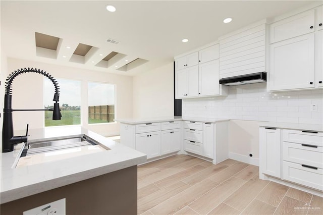 1027 Broken Arrow Dr, Alamo, TX 78516 - kitchen with a sink, a peninsula, decorative backsplash, white cabinetry, and recessed lighting