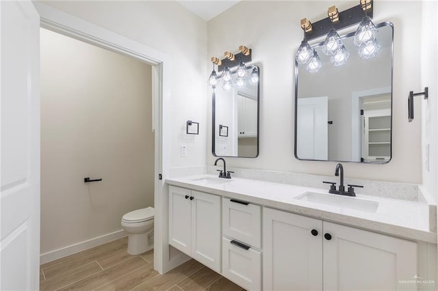 1027 Broken Arrow Dr, Alamo, TX 78516 - full bath with double vanity, toilet, wood finished floors, and baseboards