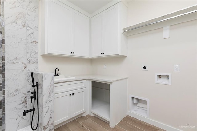 1027 Broken Arrow Dr, Alamo, TX 78516 - laundry area with electric dryer hookup, hookup for a washing machine, light wood-type flooring, cabinet space, and baseboards