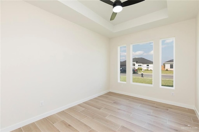 1027 Broken Arrow Dr, Alamo, TX 78516 - unfurnished room with light wood finished floors, baseboards, a tray ceiling, and ceiling fan