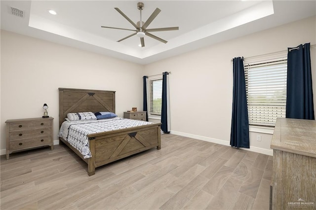 8101 N 5th St, Mcallen, TX 78504 - bedroom featuring a ceiling fan, visible vents, baseboards, light wood finished floors, and a raised ceiling